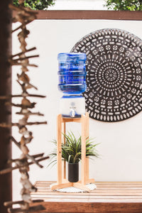 Beautiful Timber Stand with Hi Vibe Ceramic placed on top, water on ceramic. A plant is on the base of the stand with a beautiful mandala in the background. 