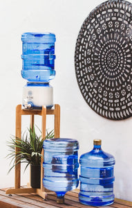 Beautiful Timber Stand with Hi Vibe Ceramic placed on top, water on ceramic and 2 15 litre water bottles next to the stand. A plant is on the base of the stand with a beautiful mandala in the background. 