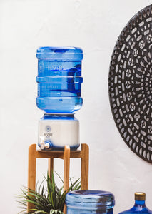 Beautiful Timber Stand with Hi Vibe Ceramic placed on top, water on ceramic and 2 15 litre water bottles next to the stand. A plant is on the base of the stand with a beautiful mandala in the background. 